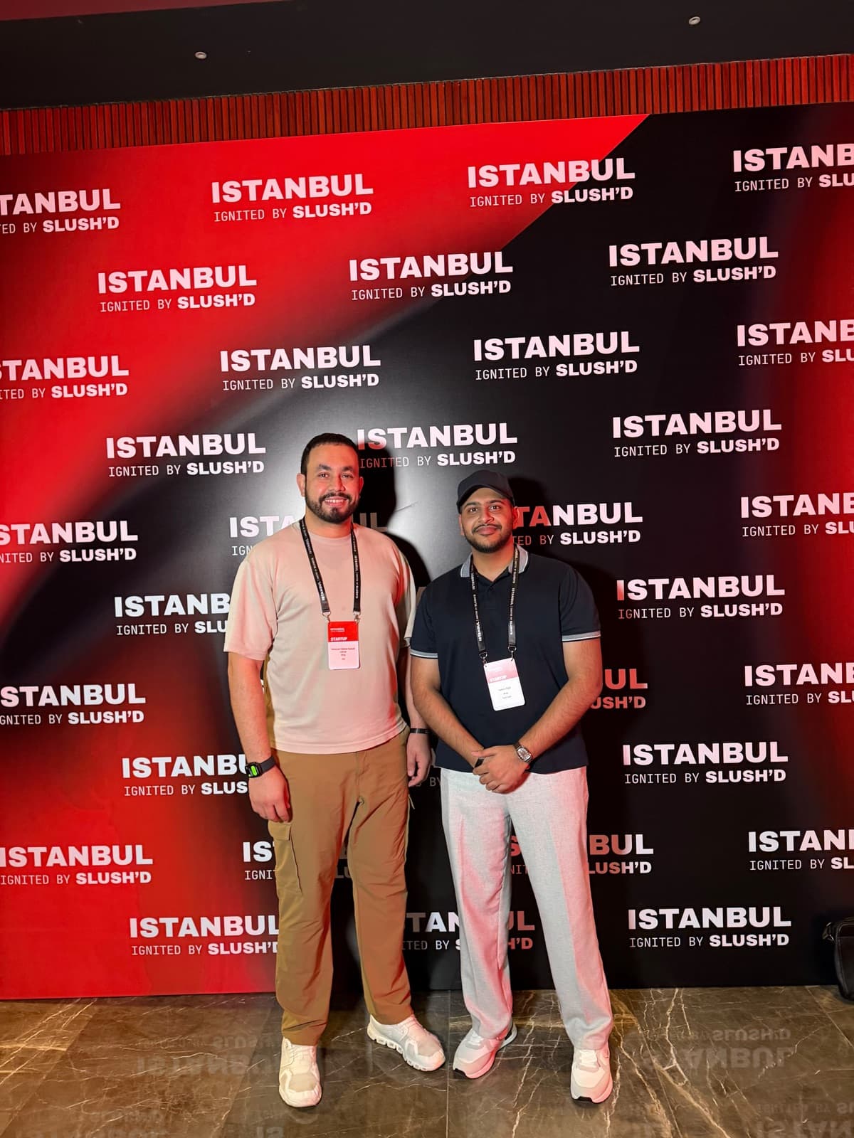 Two RFxAI team members in front of the Istanbul event backdrop